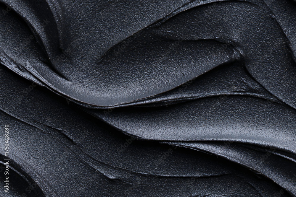 Obraz premium Deep black cosmetic clay mask texture background, full frame detail showing abstract wavy pattern, seamless for design concept.