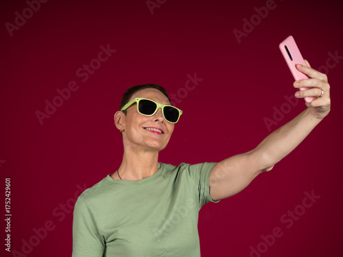 Foto Woman confidently capturing a self-portrait using smartphone