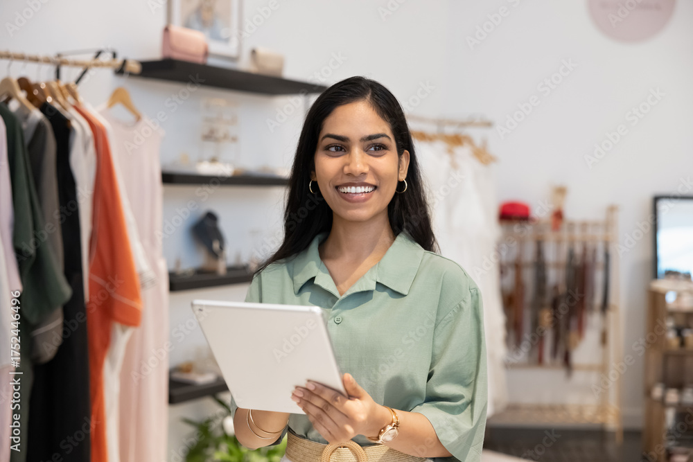 Fototapeta premium Happy Indian shopaholic girl paying for purchase on tablet
