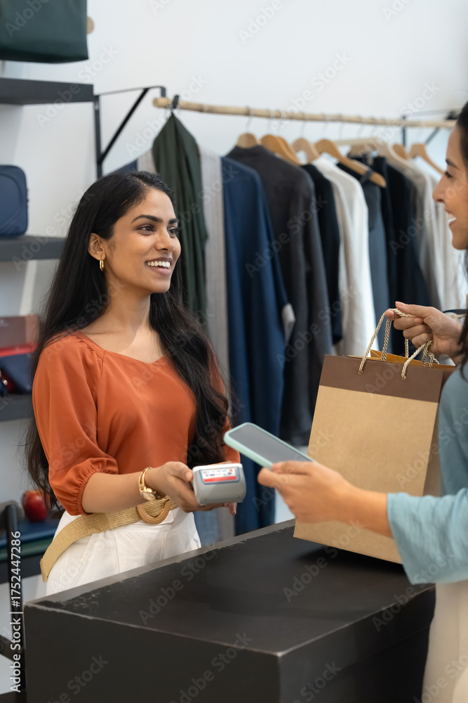 Obraz premium Happy retail professional woman offering POS terminal to customer
