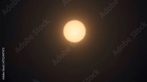 A blurred and hazy image of a glowing light source appearing as a circle, shining through darkness. The image conveys a sense of mystery, atmosphere, and the power of light to penetrate darkness.