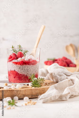 Wallpaper Mural A single glass of layered raspberry and chia seed pudding topped with fresh raspberries and white crowberry on a rustic wooden platter Torontodigital.ca