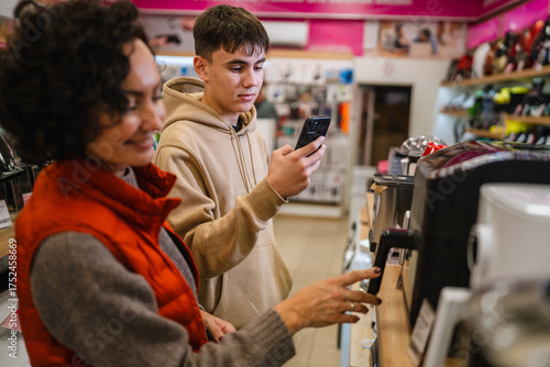 Canvas Print Mother and son comparing appliances in store