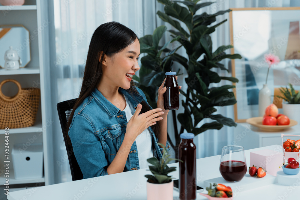 Φωτογραφία Smiling young beautiful Asian reviewing tasty mixed strawberry and cherry juice detox drinks, showing healthy product to promote for special promotion selling on social media online record