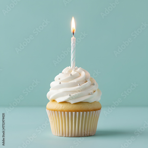 Wallpaper Mural Vanilla cupcake with white swirl frosting and silver edible pearls topped with a lit striped birthday candle against a teal background Generative AI Torontodigital.ca