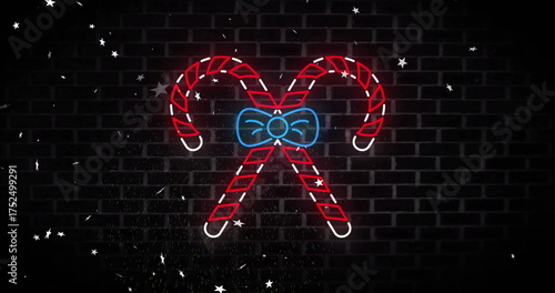 Image of neon candy canes christmas decoration over stars falling on black background