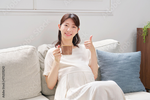 自宅でカフェインレスコーヒーを飲む妊婦　グッドサイン