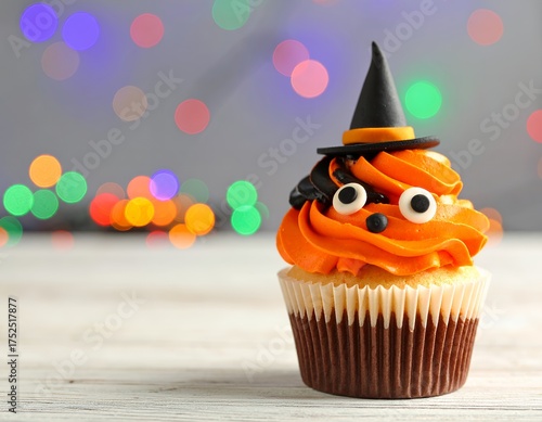 Delightful Halloween cupcake with orange frosting and witch hat decoration adds spooky sweetness to your holiday celebration this year