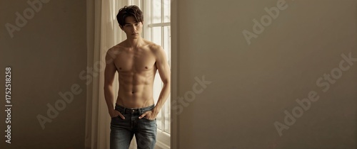 Slim young adult standing indoors with sunlight on his skin. Generative AI