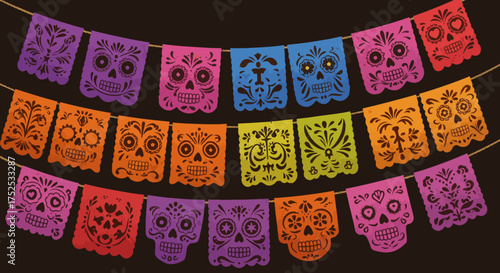 String of colorful papel picado flags each featuring a skull design strung against a dark background