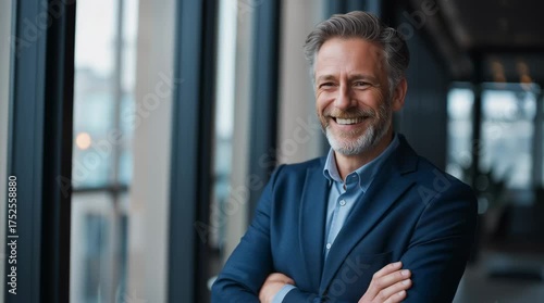 Happy middle aged business man ceo standing in office arms crossed. Smiling mature confident professional executive manager, proud lawyer, businessman leader wearing blue suit