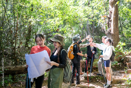 Asian friends hiking forest trail navigating with map