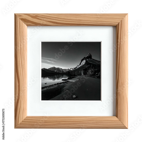 Framed black and white mountain landscape with lake and shore.