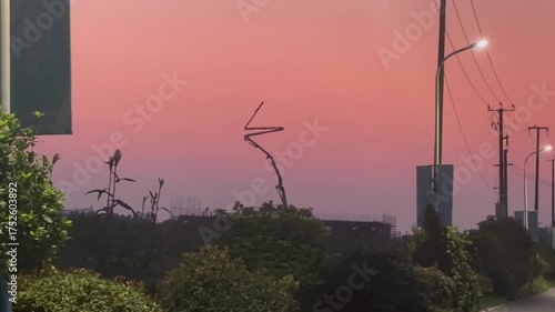 夕焼け空に建設機械が浮かぶ都市の風景映像