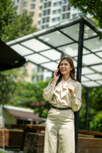 Businesswoman talking on phone integrating urban green space