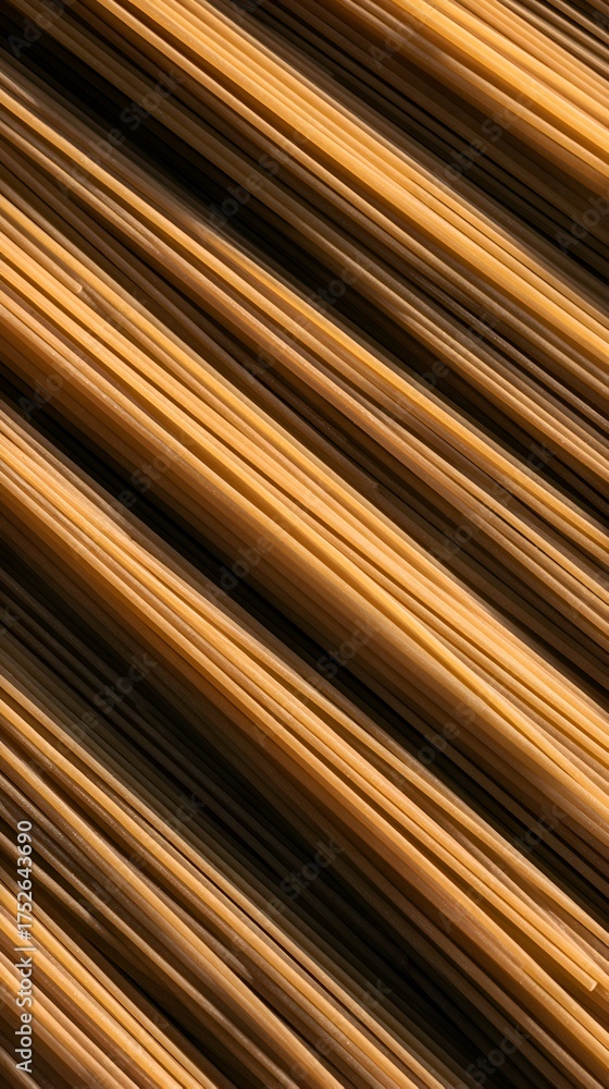 Obraz premium Close-up view of golden spaghetti strands arranged in a diagonal pattern, highlighting texture and color