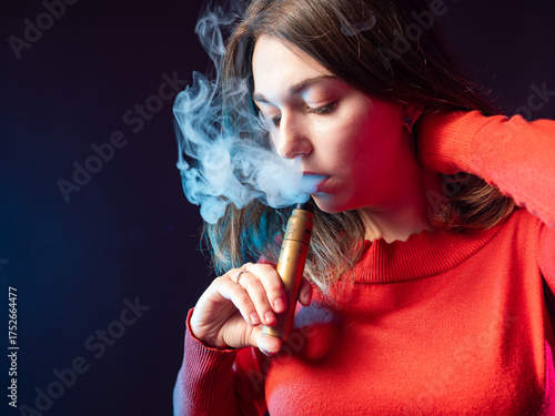 Woman smokes vape. Face gir...