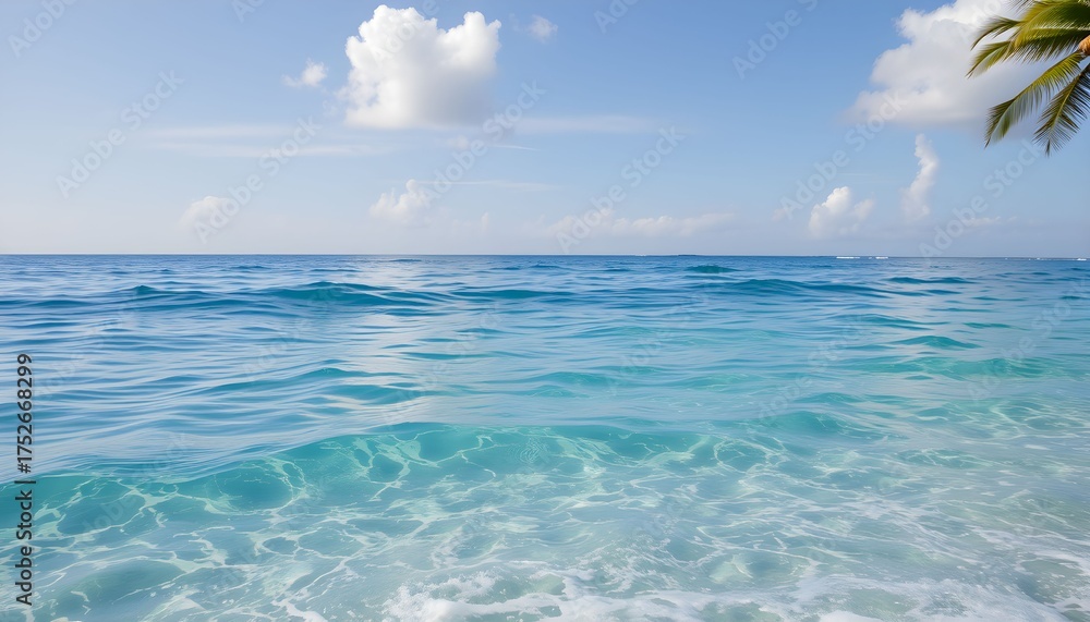 Obraz premium Clear turquoise ocean water gently laps onto a sandy beach under a bright blue sky.