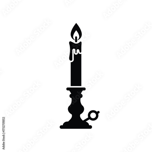 Antique candle in ornate holder burning brightly with flame and dripping wax silhouette silhouette