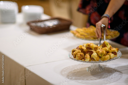 Foto Close up of golden brown pigs in a blanket appetizers being served from a clear