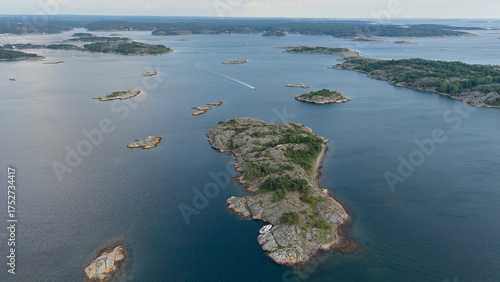 Aerial View of Rocky Islands Scattered Across the Calm Sea Near Strömstad, Sweden with Sparse Vegetation and a Boat Wake Cutting Through the Water