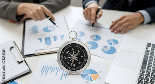Business team analyzing financial data with compass for strategic direction