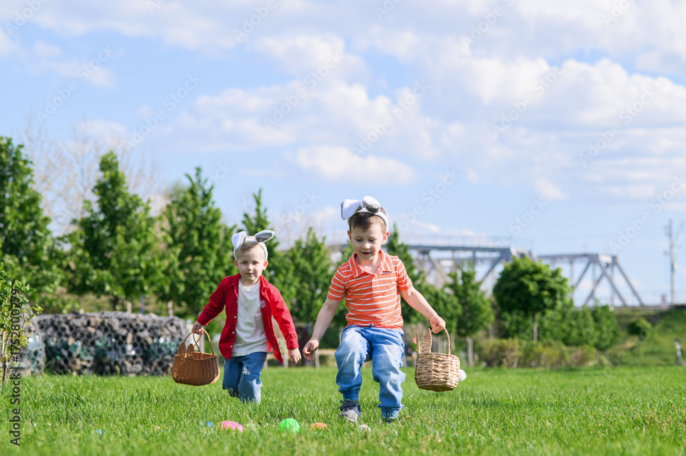 Obraz premium Kids Hunting Easter Eggs Outdoors on Sunny Spring Day