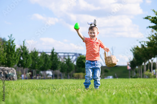 Smiling Boy Celebrating Easter Outdoors with Egg Hunt Basket
