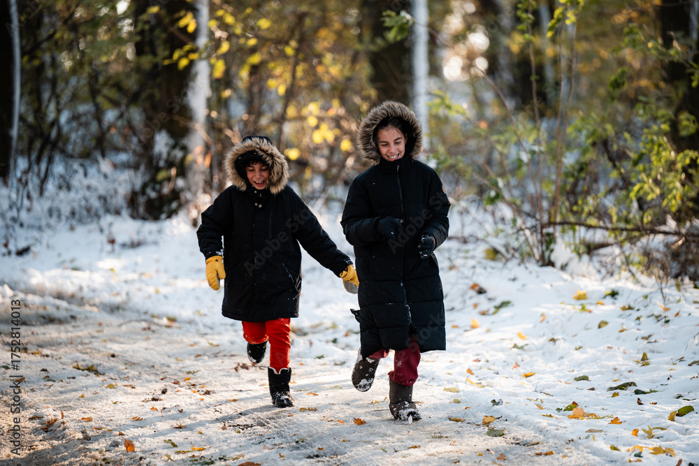 Fototapeta premium Happy children running outside playing in snow
