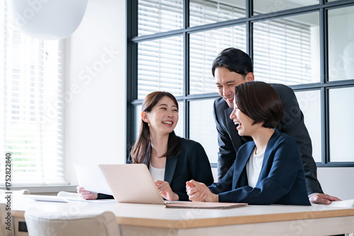 Cuadro en lienzo 社内でパソコンを見て話をするスーツを着た男女