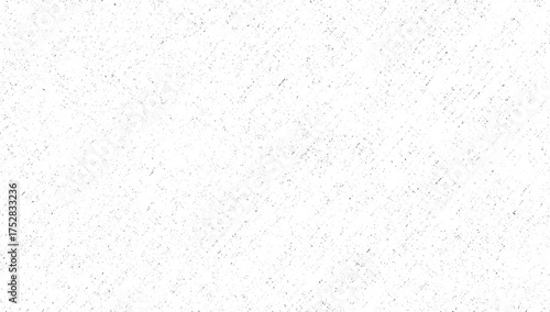 Fotografie A white surface covered with numerous small dark speckles and elongated streaks forming a textured pattern