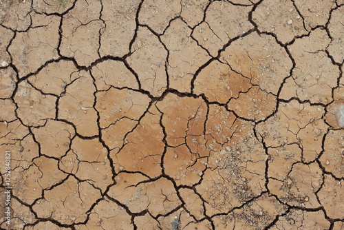 severe drought cracks the parched earth surface. arid desert soil fractures under intense heat