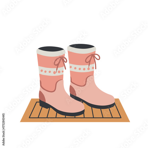 Pink winter boots on doormat ready for use in cold weather  