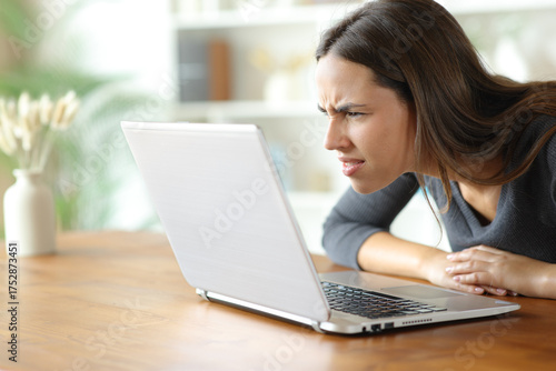 Obraz na płótnie Woman with vision problems forcing sight reading on laptop