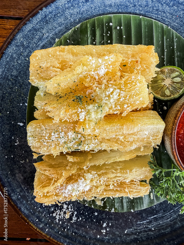Wallpaper Mural Crispy fried cassava served with spicy sambal and lime on a black plate, a traditional Indonesian snack with delicious flavor and texture. Torontodigital.ca