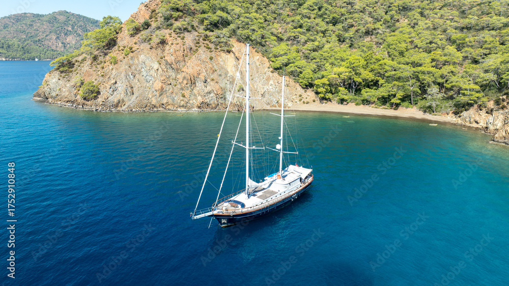 Obraz premium A breathtaking summer day with a gulet ship floating gracefully on turquoise waters.