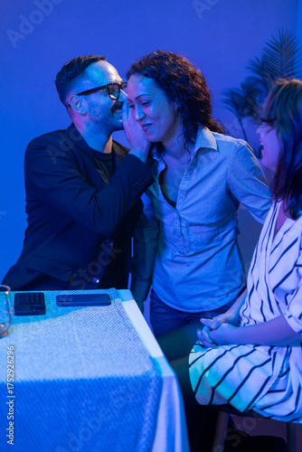 Friends gossiping during a party in blue light