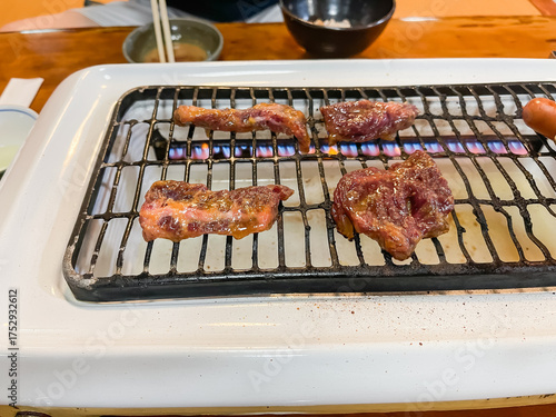 焼肉屋の風景。焼いてる牛カルビ肉と牛ロース肉・