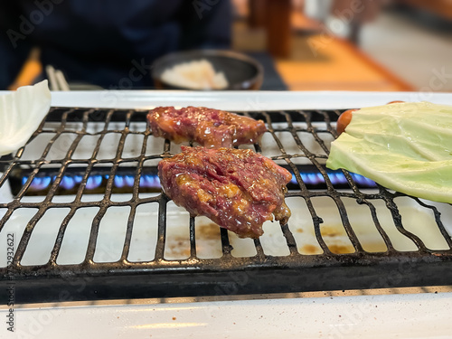 焼肉屋の風景。焼いてる味噌タレの付いた牛ロース肉。
