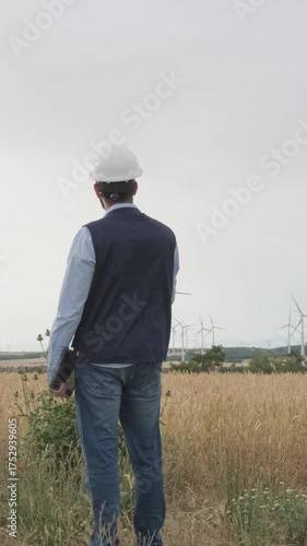 Wind turbine engineer supervising a windmill farm