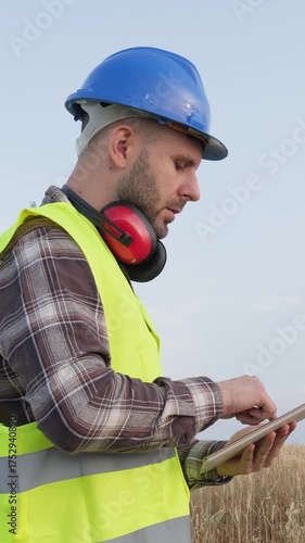 Wind turbine engineer using a digital tablet on wind farm