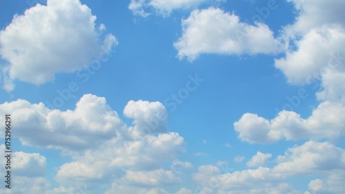 White cumulus clouds move across the blue sky. Meteorological background.