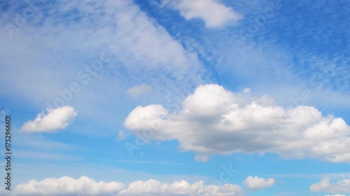 a bright blue sky filled with soft, white clouds. The clouds appear scattered and billowy, creating a serene and peaceful atmosphere. Fast moving timelapse