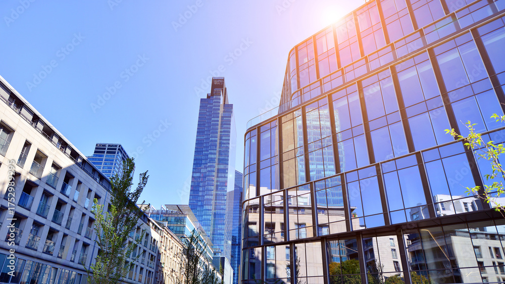 Fototapeta premium Modern luxury office building.The structure features a glass and concrete walls, showcasing contemporary architecture. The green surroundings of office buildings. Trees and shrubs in the city.