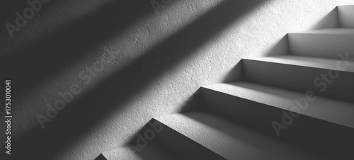 Dramatic grayscale image showing concrete stairs ascending with strong shadows