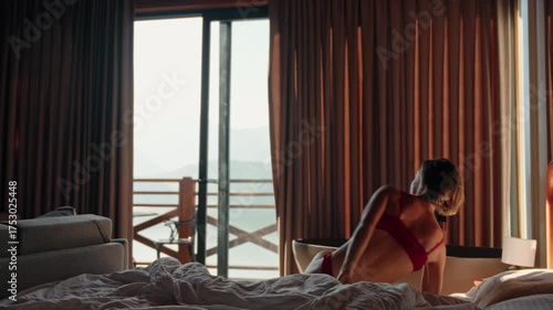 Young woman wakes up and stretches in bed on a sunny morning in a wooden countryside house. Peaceful start of the day, concept of digital detox, relaxation and slow lifestyle. High quality 4k footage