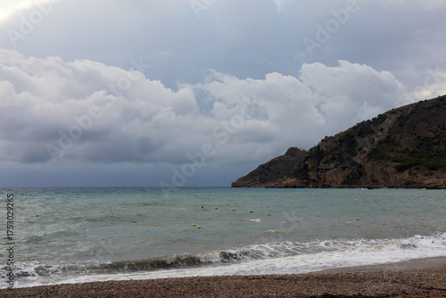 Sunrise over the sea with gentle waves washing the sandy beach, reflecting the golden sunlight. Peaceful and harmonious natural landscape.