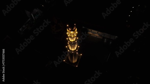 Aerial view of mosque at night in Malang, Indonesia, with backward tilt up movement