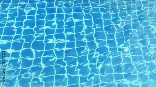Top view of clear blue swimming pool water surface with sunlight reflections and smooth ripples, abstract background for relaxation and summer concept