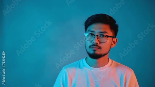 A man wearing glasses and a white shirt. He has a beard and is looking at the camera